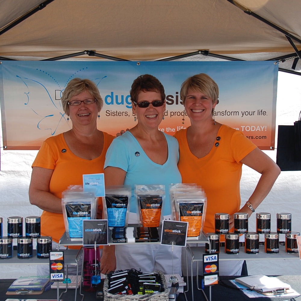 3 sisters in a market tent with deodorant display in front