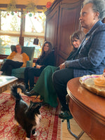 Moo Moo our black and white kitty looking up at Mayor Lori Lightfoot, who is wearing a blue suit